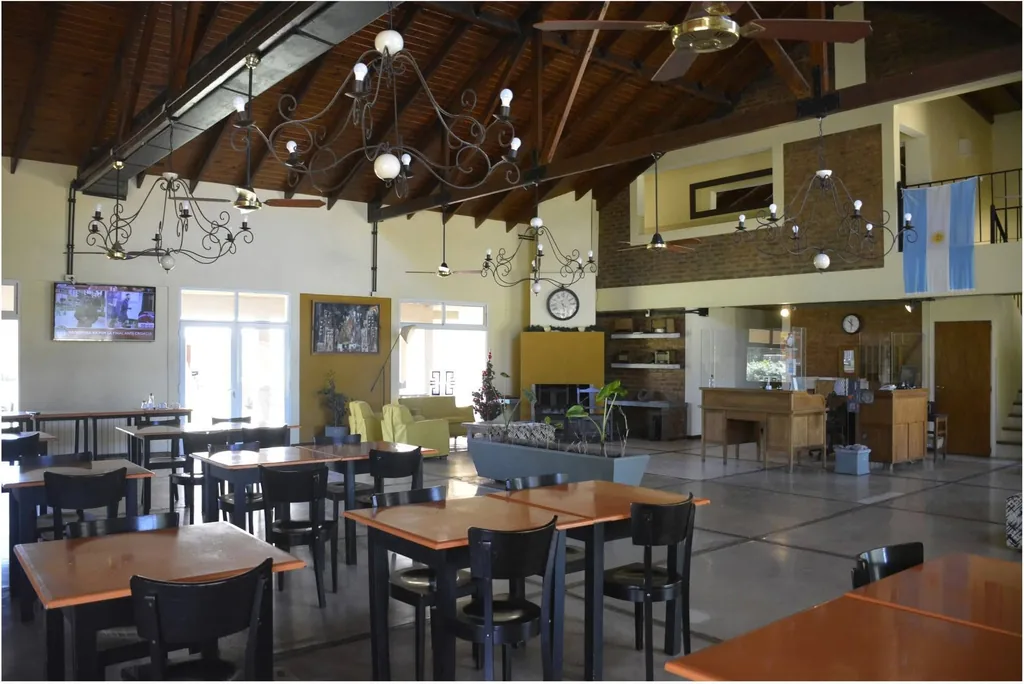Comedor con mesas de madera bajo arañas de hierro