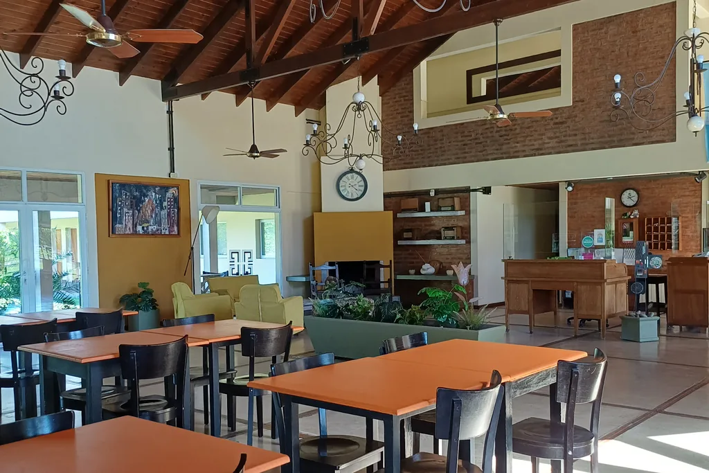 Salón comedor con techo de madera, arañas de hierro y hogar